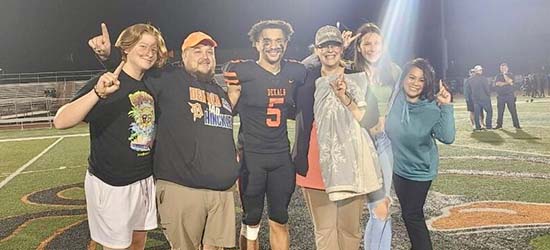 Colleen Fitzpatrick pictured with her family; Tho Pham, Resource Bank Bethany Branch Manager; and Toriano Tate (#5) on the DeKalb football field. 